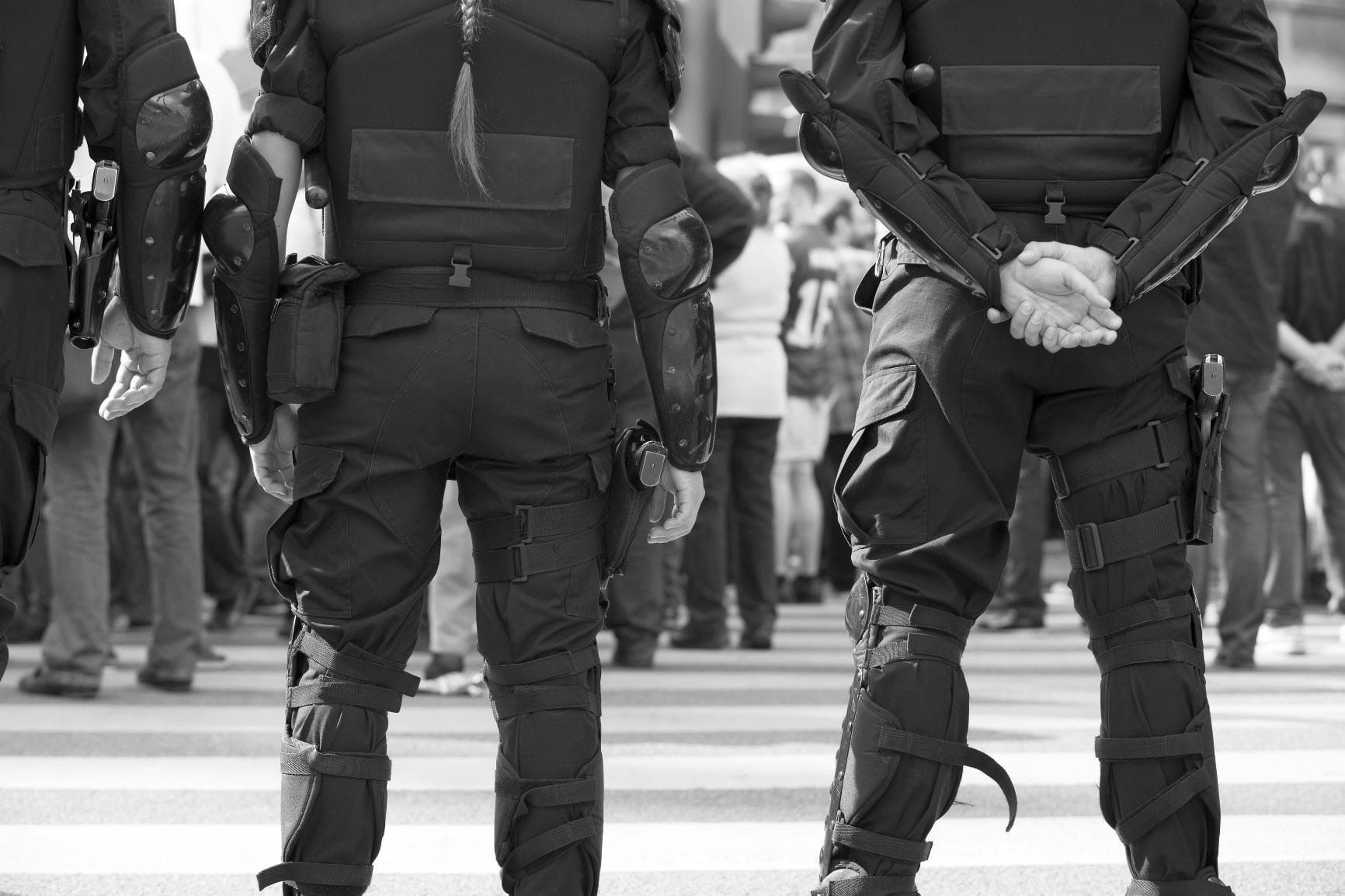 police officers facing a crowd and wearing body armor